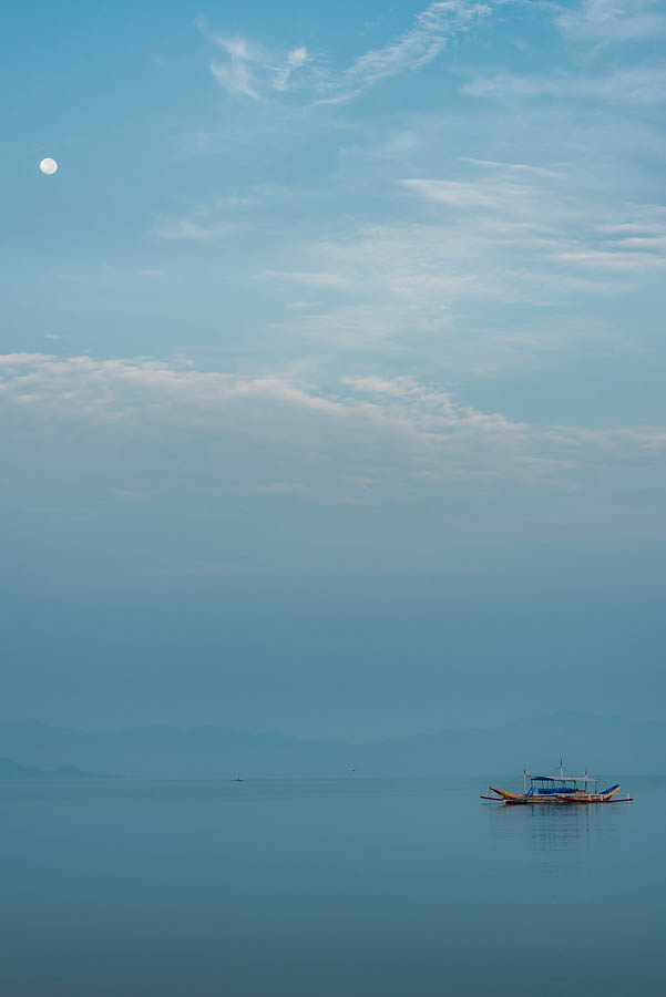 Foto Amanecer Port Barton, encontramos la luna alineada con el barco típico Filipino, la bangka