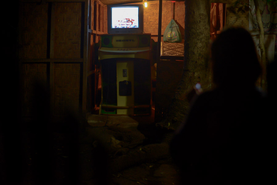 Mujer encendiendo un cogarro y cantando Karaoke, Filipinas