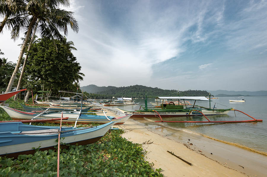 Barcos amarrados en la orilla de la playa de Port Barton, Filipinas